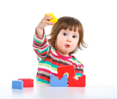 A smiling little girl is building a toy block. Isolated on white background