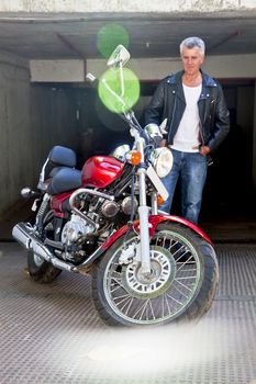 Vertical take of a red cruiser motorcycle and its doting admirer. Caucasian model and generic photograph was taken in Bombay India