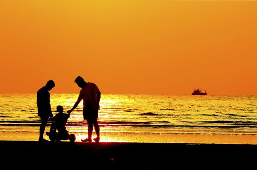 Silhouette image of father  child by the sea shore, sunset