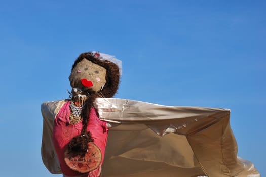 scarecrow with cape and blue sky