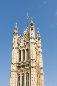 One of the towers of Houses of Parliament in London, UK, with British Union flag atop.