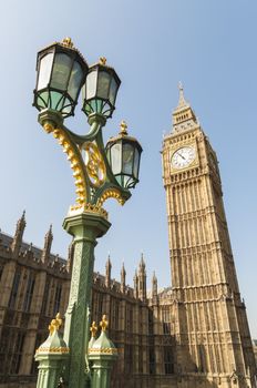 Low angle shot of Big Ben in London, with ornamented lamppost in the foreground.