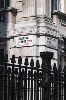 LONDON, UK - APRIL 02: Downing Street nameplate in the corner with Whitehall, with black gates in the lower third. April 02, 2012 in London.