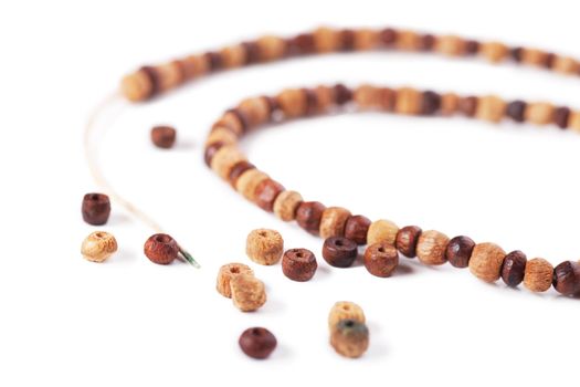 The torn necklace from wooden beads on a white background