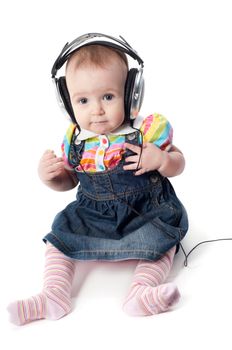 Studio shot of little cute baby in headphones girl