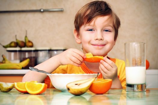 boy, breakfast, drinks milk, eats cereal and orange