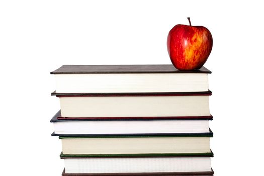 Red apple resting on top of a pile of books