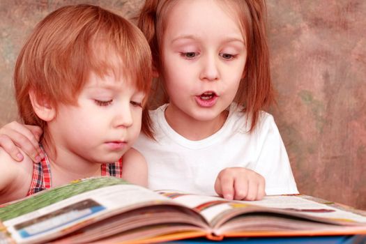 girl and boy friendly reading an interesting book