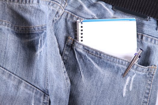 A notebook in some jeans trousers.