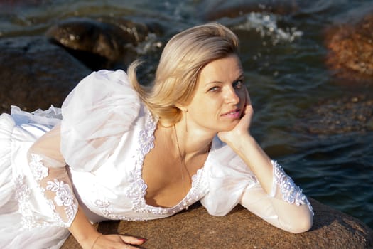 Woman lying on rock at seaside