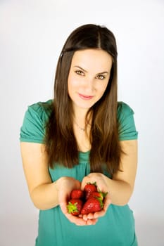 cute female model with strawberries in her hands smiling