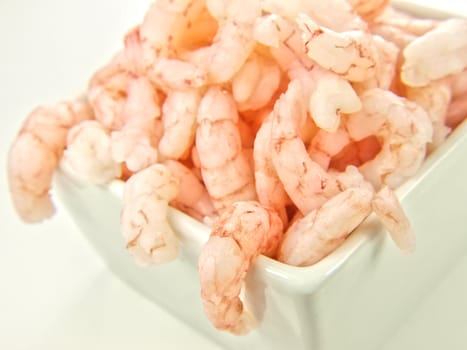 Peeled shrimps, isolated in a white bowl towards white