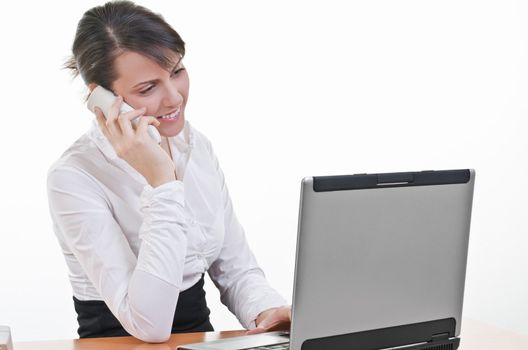 A portrait of office assistant looking at laptop screen and answering phone call, focus on eyes, horizontal shot