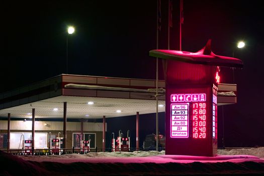Kind on a gasoline station in the winter at night
