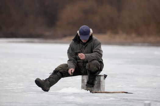 The fisherman on winter fishing fishes