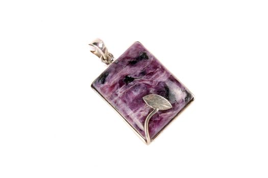 A beautiful chorite pendant used as jewelery accessory or in alternative healing methods like crystal healing or astrology, on white studio background.