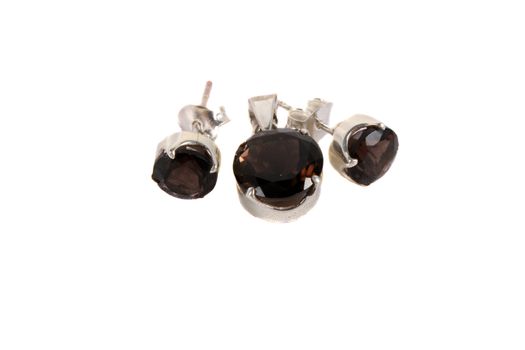 A jewelery set of pendant and earrings made of smoky quartz gemstones, isolated on white studio background.