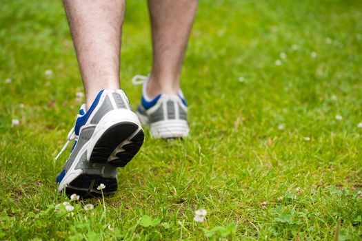 legs of walking man on grass