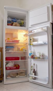 An open white refrigerator with stuff within