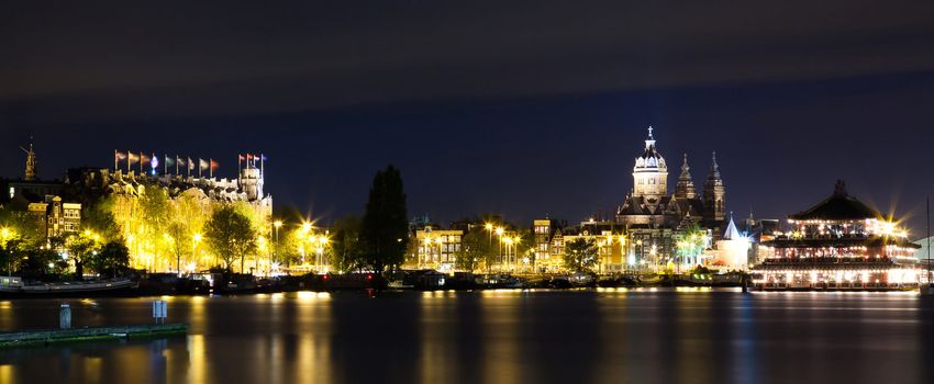 Amsterdam night panorama - view on Sea Palace, Church of St. Nicholas and Grand Hotel Amrath - long time exposure