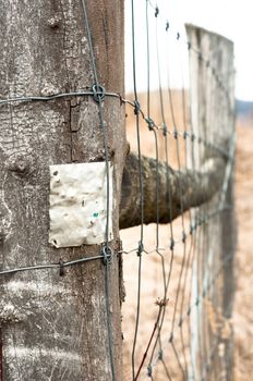 Wooden fence with metal plate against blurry background