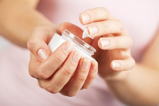 beautiful woman hands applying cream