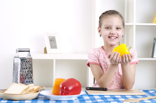 beautiful young girl cooking vegetables for a salad, working in kitchen