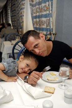 A father and his daughter at dinner table smiling