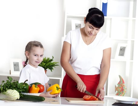 Mother and daughter cooking vegetable salad together