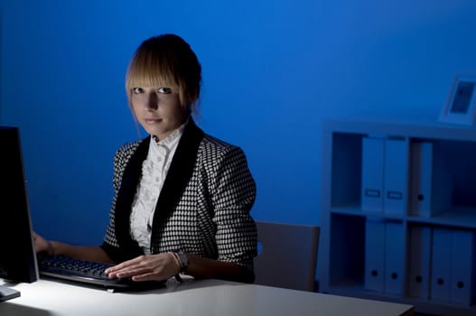 beautiful young business woman working at night in the office