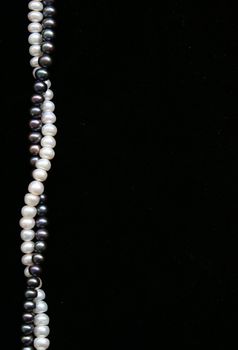 White and black pearls on the black velvet can use as background