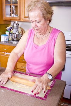 Older lady prepearing Turkish Pide pockets dough in the kitchen.