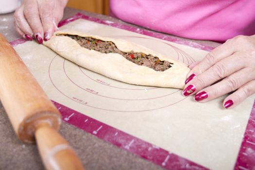 Turkish Pide pocket filled with ground beef roasted peppers, tomatoes, parsley and seasoning getting ready to go to oven.