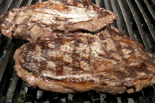 two steaks cooked on a grill in the restaurant