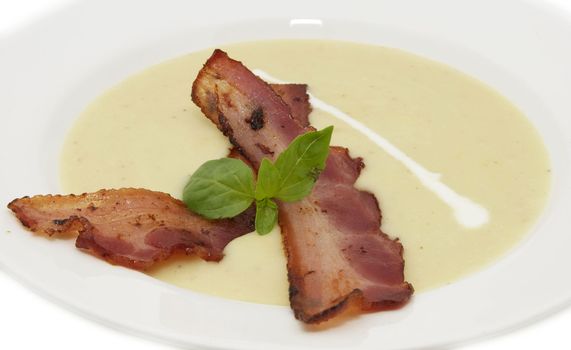 pea soup with bacon on a white plate