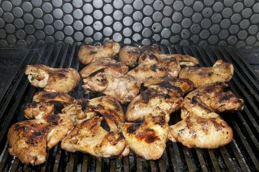 a lot of chicken wings cooked on the grill
