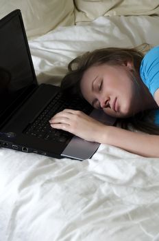 Young girl student was tired and fell asleep on a laptop