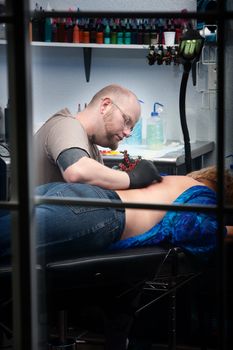 Window view of tattoo artist working with client