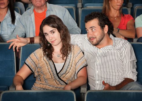 Man flirts with young woman in theater