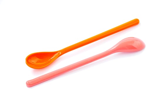 A pair of plastic spoons on a white background
