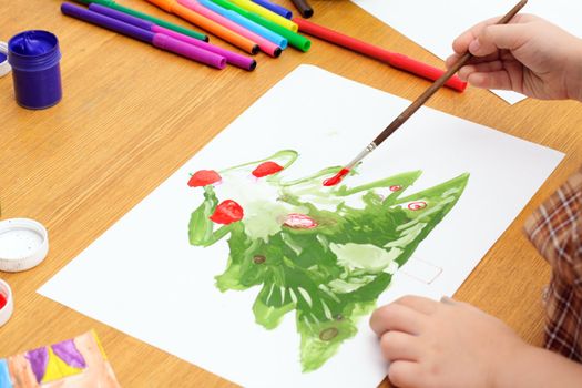 child draws a tree; hands, paint, markers