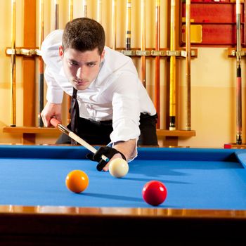 Billiard winner handsome man playing with cue and balls at club
