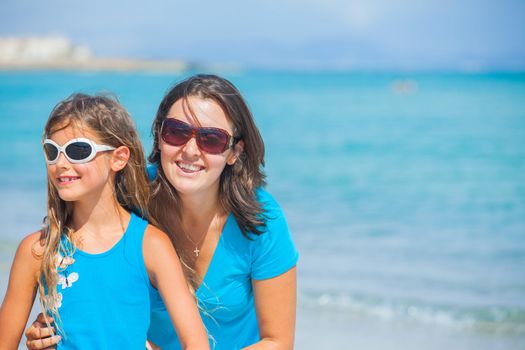 Clouseup portrait of mother and her daughter having fun on tropical beach