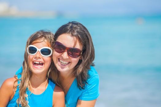 Clouseup portrait of mother and her daughter having fun on tropical beach