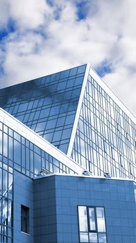 Architectural details of a modern building of business type on a background of the cloudy sky