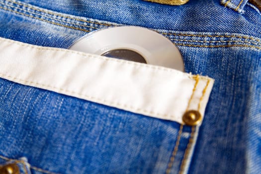 compact disk with modern music against fashionable blue jeans