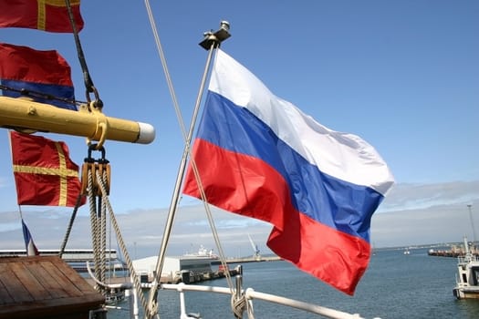 Russian flag of a sailing vessel against the sea in port