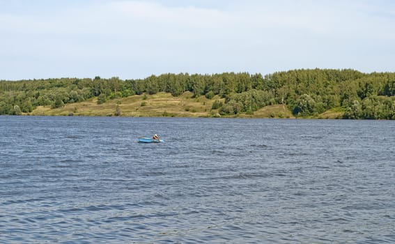 Bank of the Volga river with a lone fisherman in a boat
