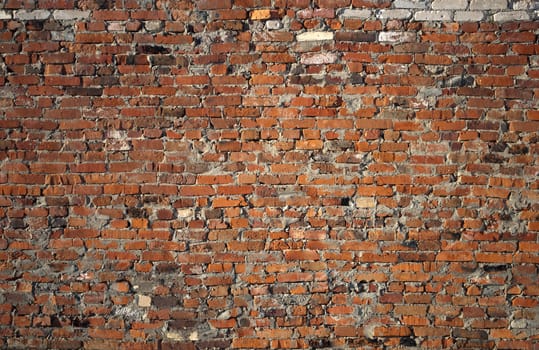 Closeup of weathered red brick wall background