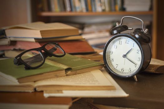 Pile of old books with clock